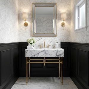 Puede incluir: Un lavabo de mármol blanco con estructura de metal dorado, que incluye una cubeta rectangular, grifo dorado y un espejo a juego con marco dorado. El mueble está flanqueado por dos lámparas de pared con pantallas beige sobre paneles negros.