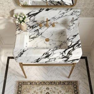 Luxury Calacatta Lilac marble bathroom vanity sink viewed from above, featuring dramatic charcoal and gray veining, a handcrafted integrated stone basin, elegant brushed brass console legs, premium marble backsplash, and refined contemporary styling for luxury bathrooms, powder rooms, boutique hotels, and high-end interior design projects.