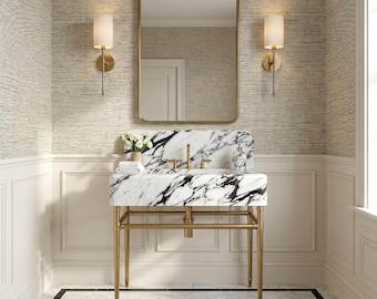 May include: A white marble sink with bold black veining supported by a gold metal frame. The sink features a matching marble backsplash, a gold faucet, and a gold drain. Above the sink is a rectangular mirror with a gold frame and two gold wall sconces.