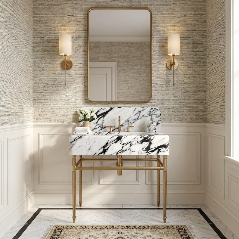 Elegant bathroom featuring a handcrafted Calacatta Lilac marble bathroom vanity sink with striking natural veining, integrated stone basin, polished marble backsplash, brushed brass console legs, designer mirror, wall sconces, and timeless luxury finishes, ideal for custom homes, powder rooms, boutique hotels, and sophisticated bathroom renovations.