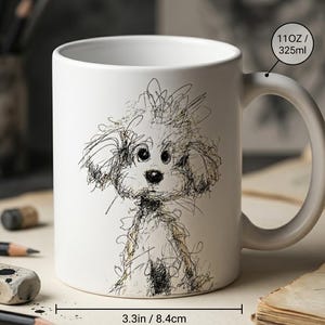 May include: A white ceramic mug featuring a black ink sketch of a fluffy dog. The mug has a capacity of 11 ounces, a height of 3.74 inches, and a diameter of 3.3 inches. The design consists of loose, scribbled lines forming the dog's face and body.