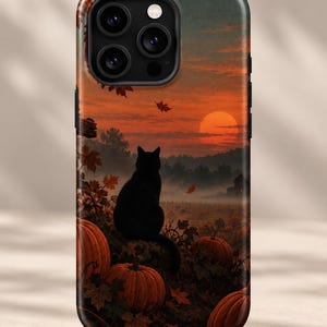 May include: A smartphone case featuring a printed scene of a black cat sitting in a pumpkin patch during a sunset. The image displays orange pumpkins, falling autumn leaves, and a dark silhouette of a cat against a vibrant orange sky.