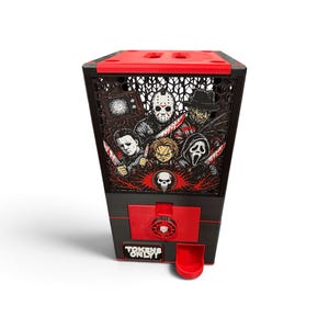 Könnte beinhalten: Ein schwarz-roter Token-Spender mit einer Grafikplatte, die Horrorfilm-Charaktere wie Jason Voorhees, Michael Myers, Chucky und Ghostface zeigt. Die Vorderseite enthält einen roten Münzschlitz, eine rote Ausgabeschale und ein Schild mit TOKENS ONLY.