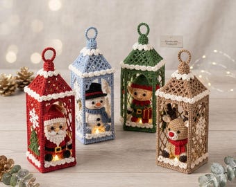 May include: Four crocheted lantern ornaments featuring holiday characters: a red Santa, a blue snowman, a green elf, and a tan reindeer. Each lantern has a lattice frame, white trim, a top hanging loop, and an internal light. A tag reads Handmade Treasures.