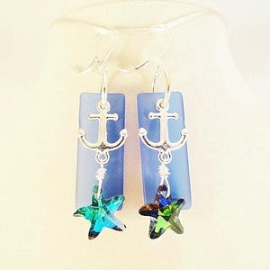 May include: A pair of silver anchor earrings with blue glass and green crystal starfish charms.