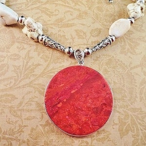 May include: A red coral pendant necklace with white howlite beads and a silver chain.