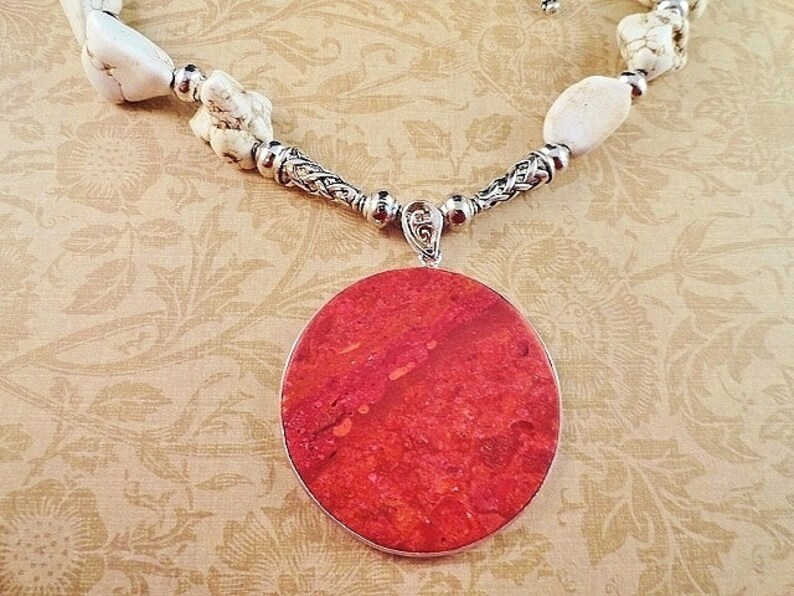 May include: A red coral pendant necklace with white howlite beads and a silver chain.
