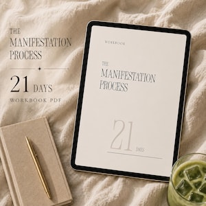 Peut inclure: Une tablette numérique affichant un manuel intitulé The Manifestation Process 21 Days, accompagnée d'un carnet beige, d'un stylo doré et d'un verre de thé vert glacé. Le texte à l'écran indique Workbook, The Manifestation Process et 21 Days.