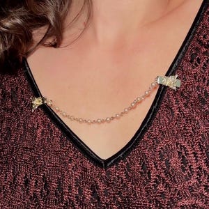 These vintage sweater clips are an absolute treasure. Featuring light gold butterfly clips connected to a cream pearl linked chain. These whimsical butterflies have small alligator clips that gently and securely clip to a cardigan/sweater/jacket/collar, for an instantly elevated look. Sweater clips are a classic vintage accessory popular in the 1940s and 1950s.