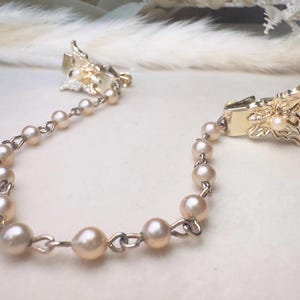 These vintage sweater clips are an absolute treasure. Featuring light gold butterfly clips connected to a cream pearl linked chain. These whimsical butterflies have small alligator clips that gently and securely clip to a cardigan/sweater/jacket/collar, for an instantly elevated look. Sweater clips are a classic vintage accessory popular in the 1940s and 1950s.
