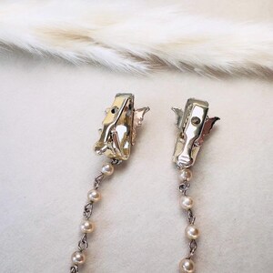 These vintage sweater clips are an absolute treasure. Featuring light gold butterfly clips connected to a cream pearl linked chain. These whimsical butterflies have small alligator clips that gently and securely clip to a cardigan/sweater/jacket/collar, for an instantly elevated look. Sweater clips are a classic vintage accessory popular in the 1940s and 1950s.