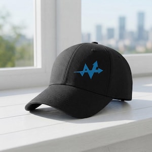 May include: A black baseball cap featuring a bright blue graphic logo on the front panel. The logo consists of a stylised letter A integrated with an arrow design pointing towards the right. The cap has a structured crown and a curved brim.