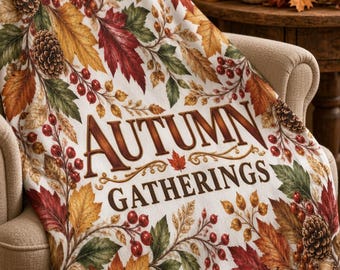 Peut inclure: Un plaid blanc orné d'un motif automnal coloré composé de feuilles rouges, orange et vertes, de pommes de pin et de baies rouges. Le texte "AUTUMN GATHERINGS" est imprimé au centre dans une police serif décorative marron foncé.