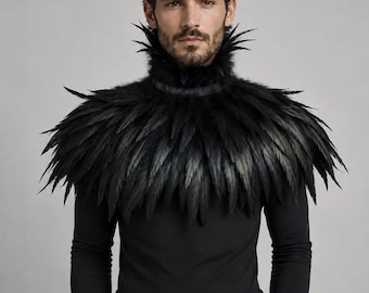 Puede incluir: Un cuello de plumas negras con una pieza de cuello alta y estructurada, y plumas puntiagudas en capas que caen sobre los hombros. El accesorio se lleva sobre una camiseta negra de manga larga, creando una apariencia dramática y texturizada.