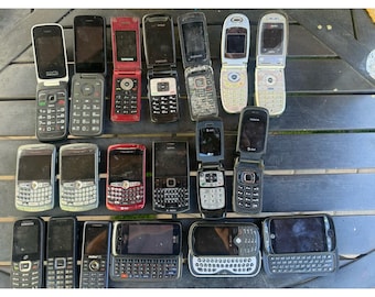 May include: A collection of twenty assorted vintage mobile phones arranged in three rows. The group includes various flip phones with numeric keypads and candy-bar style devices featuring full QWERTY keyboards, displaying brands like Samsung, BlackBerry, Nokia, and AT&T.