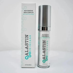 May include: A white rectangular box and a matching cylindrical pump bottle of Alastin Skincare Restorative Skin Complex with TriHex Technology. Both items feature teal hexagonal branding and text stating 1.0 Fl. Oz. 29.6 mL on the front.