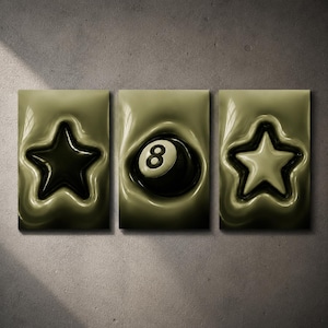 May include: A three-piece wall art set featuring a monochromatic olive-green theme. The left panel displays a dark star, the center panel shows a black eight ball, and the right panel features a light-colored star, all with a glossy, liquid-like effect.