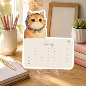 May include: A desktop calendar featuring an illustration of an orange cat wearing a green headscarf. The calendar page displays the month of February with the number 02 in the top right corner, set against a light beige background with black text.