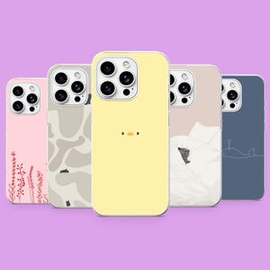 May include: Five smartphone cases featuring distinct designs: a pink case with red floral stems, a beige abstract pattern, a yellow case with a small duck face, a beige case with a cat in white bedding, and a blue case with a white whale outline.