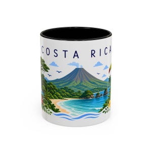May include: A white ceramic mug with a black interior and rim, featuring a colorful graphic of a Costa Rican landscape with a volcano, tropical foliage, a sandy beach, blue ocean waves, and a toucan, with the text COSTA RICA printed at the top.