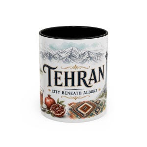 May include: A white ceramic mug with a black interior featuring a detailed illustration of the Alborz mountains, a pomegranate, and a patterned rug. The text reads TEHRAN CITY BENEATH ALBORZ in dark blue and gold lettering against a white background.