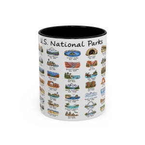 May include: A white ceramic mug with a black interior and rim, featuring a colorful grid of illustrations depicting various U.S. National Parks. The text U.S. National Parks is printed at the top, with individual park names and establishment dates below each icon.