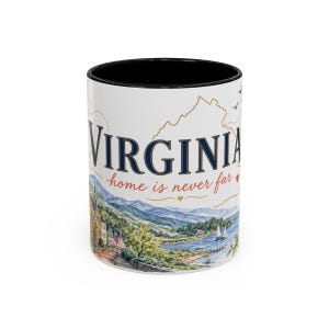 Könnte beinhalten: Ein weißer Keramikbecher mit schwarzem Innenraum und Rand. Die Außenseite zeigt eine Aquarell-Landschaft von Virginia mit Bergen, einem See und Segelbooten. Der Text VIRGINIA ist in großen blauen Buchstaben mit dem Schriftzug home is never far gedruckt.
