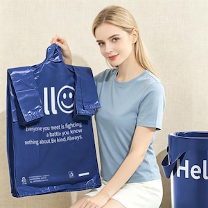 Puede incluir: Una pila de bolsas de envío de plástico azul oscuro con un icono de cara sonriente blanca, el texto "llo" y la cita "Everyone you meet is fighting a battle you know nothing about. Be kind. Always." Un contenedor cilíndrico azul es visible.