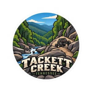 May include: A circular sticker featuring a landscape illustration of a rocky creek with a small waterfall, green trees, blue mountains, and a black off-road vehicle on a dirt path. The text TACKETT CREEK TENNESSEE is printed in bold white letters.