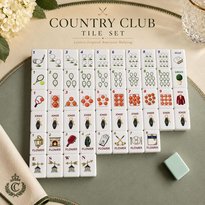 May include: A white American Mahjong tile set titled Country Club Tile Set. The tiles feature colorful illustrations of golf balls, tennis rackets, pickleballs, keychains, and various leisure-themed icons, with numbers 1 through 9 and Joker tiles.