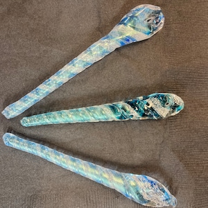 May include: Three glass ornaments with a blue and white swirl design. The ornaments are clear glass with a blue and white swirl pattern.