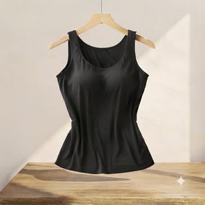 May include: A solid black sleeveless tank top with a scoop neckline, featuring integrated molded cups for structure. The garment is displayed on a wooden hanger, showcasing a smooth, matte fabric finish and a fitted silhouette throughout the torso.