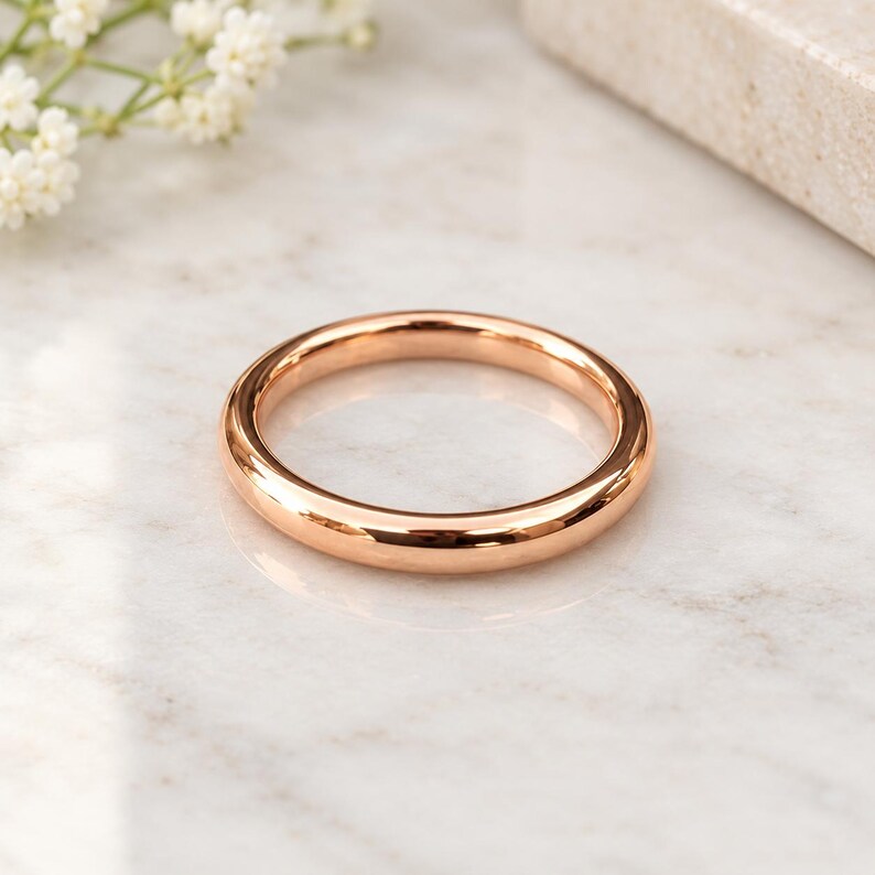 K&ouml;nnte beinhalten: Ein polierter Ring aus Ros&eacute;gold mit einer glatten, abgerundeten Oberfl&auml;che. Das Metall hat einen warmen, metallisch-rosa Farbton und ein reflektierendes Finish. Der Ring ist kreisf&ouml;rmig und hat ein schlichtes, massives Design ohne Steine.