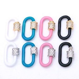 May include: Eight oval-shaped carabiner clasps arranged in two rows. The top row features white, turquoise, pink, and black enamel links with gold-tone screw mechanisms encrusted with clear crystals. The bottom row mirrors these colors with silver-tone crystal-set screw mechanisms.