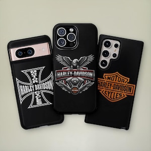 Pode incluir: Três capas pretas para smartphone com a marca Harley-Davidson. A capa da esquerda exibe uma cruz de ferro branca com texto. A central mostra um emblema de águia sobre peças de motor. A da direita apresenta um logótipo laranja com texto.