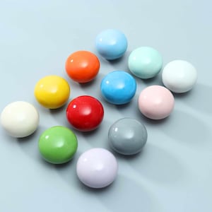 May include: A collection of twelve spherical knobs in a variety of solid colors including red, orange, yellow, green, blue, light blue, white, gray, pink, and lavender. Each knob has a smooth, glossy finish and a rounded, uniform shape.
