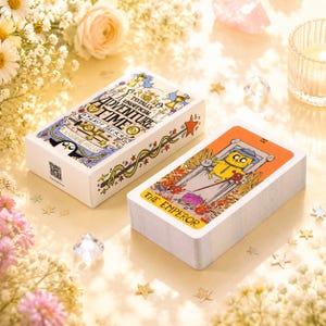 May include: A deck of Adventure Time tarot cards featuring a white box with the text A TOTALLY UNOFFICIAL ADVENTURE TIME TAROT DECK and a card showing a yellow character in a blue hat labelled THE EMPEROR with an orange border and illustration.
