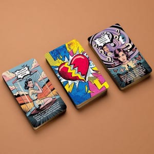 Op de afbeelding: Drie rechthoekige kaartspellen met pop-art illustraties. De linkerkaart toont een persoon in een glazen doos met tekst. De middelste kaart toont een groot rood gebroken hart. De rechterkaart toont een persoon omringd door vraagtekens en tekst.