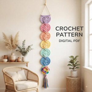 May include: A vertical wall hanging featuring a series of seven crocheted circular motifs in a rainbow gradient, suspended by a string. The bottom motif is a multi-colored flower with a long, multicolored tassel. Text reads CROCHET PATTERN DIGITAL PDF.