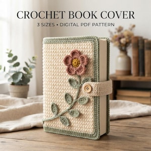 May include: A cream-colored crochet book cover featuring a pink flower with a yellow center and green leaves. The cover has a sage green border and a matching strap with a wooden button. Text reads: CROCHET BOOK COVER 3 SIZES DIGITAL PDF PATTERN.