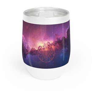 May include: A stainless steel tumbler featuring a vibrant galaxy print with shades of purple, pink, and deep blue. A thin, orange-toned geometric mandala design is centered on the front. The tumbler has a white rim and a white base with a clear lid.