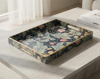 May include: A rectangular serving tray featuring a dark navy blue background with a dense botanical pattern of light green acanthus leaves, pink carnations, and yellow daisies. The tray has a thin gold-toned metal rim and integrated handles.