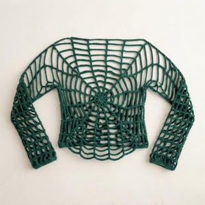 May include: A dark forest green long-sleeve sweater crafted with a crochet technique. The garment features an open-knit construction that forms a repeating spider web pattern radiating from the center of the chest outward to the sleeves.