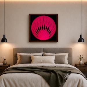 Puede incluir: Una pieza de arte mural cuadrada que presenta un diseño circular de arte con hilos en color rosa vibrante sobre un fondo negro profundo, encerrada en un marco de madera marrón oscuro. El patrón intrincado irradia desde el centro, creando un efecto geométrico.