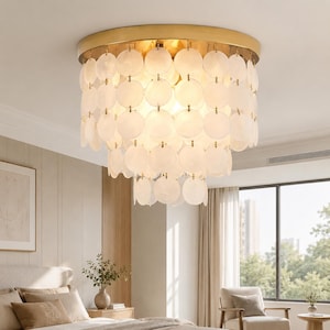May include: A flush mount ceiling light fixture featuring a circular gold-toned metal frame. The fixture is adorned with multiple tiers of translucent, circular white shell discs suspended by small metal rings, creating a layered, cascading effect.