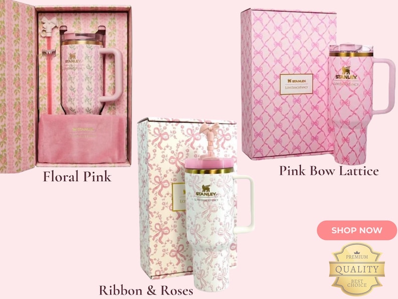 May include: Three Stanley tumblers with handles and lids, each presented in a matching patterned box. The designs include a floral pink print, a pink bow lattice pattern, and a white ribbon and roses motif, all featuring gold-tone accents.