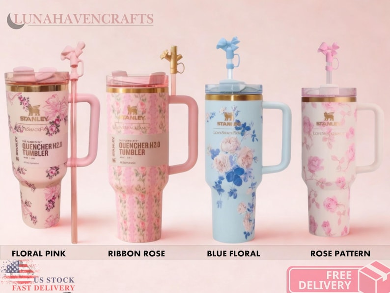 May include: Four Stanley Quencher H2.0 tumblers with handles and straws. The first is pink with floral patterns, the second is pink with ribbon rose designs, the third is light blue with floral prints, and the fourth is white with pink rose patterns.