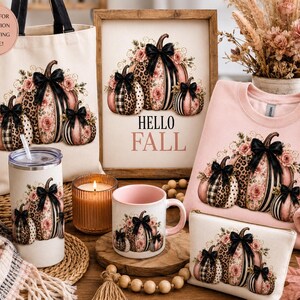 Könnte beinhalten: Eine Kollektion mit Kürbisdruck, schwarzen Schleifen, Blumenmustern und Leopardenflecken. Enthält eine Stofftasche, ein gerahmtes Schild mit dem Text HELLO FALL, ein hellrosa Sweatshirt, einen Becher, eine Tasse und eine Reißverschlusstasche.