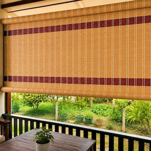 May include: A roll-up bamboo shade featuring a natural tan finish with two horizontal dark red stripes. The shade is constructed from thin, vertical bamboo slats held together by white thread, and includes a white pull cord on the right side.