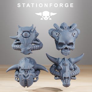 May include: Four grey resin miniature heads from StationForge, each featuring distinct sci-fi designs including a cyclopean helmet, a mechanical skull, a horned helmet with facial plating, and a skeletal creature head with large curved horns.